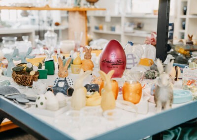 Bunte Tischdekoration mit verschiedenen Osterfiguren und Utensilien, einschließlich Hasen und Eiern, dekoriert und ansprechend angeordnet.